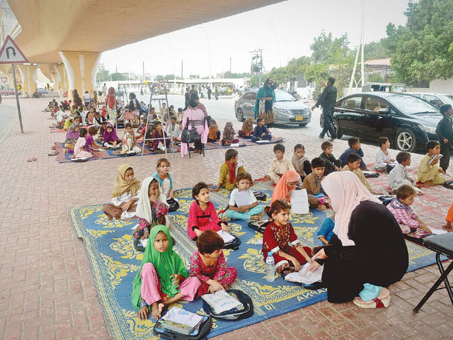 کراچی ،بچوں کیلئے سڑک کنارے فٹ پاتھ اسکول کے قیام سے غریب بچے علم حاصل کرنے میں مشغول